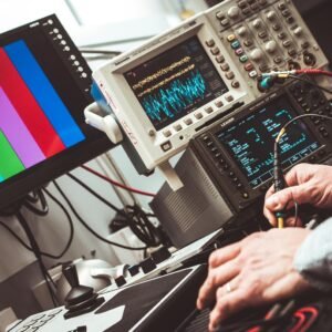 Technician operating laboratory electronic testing and measurement devices with colorful display.